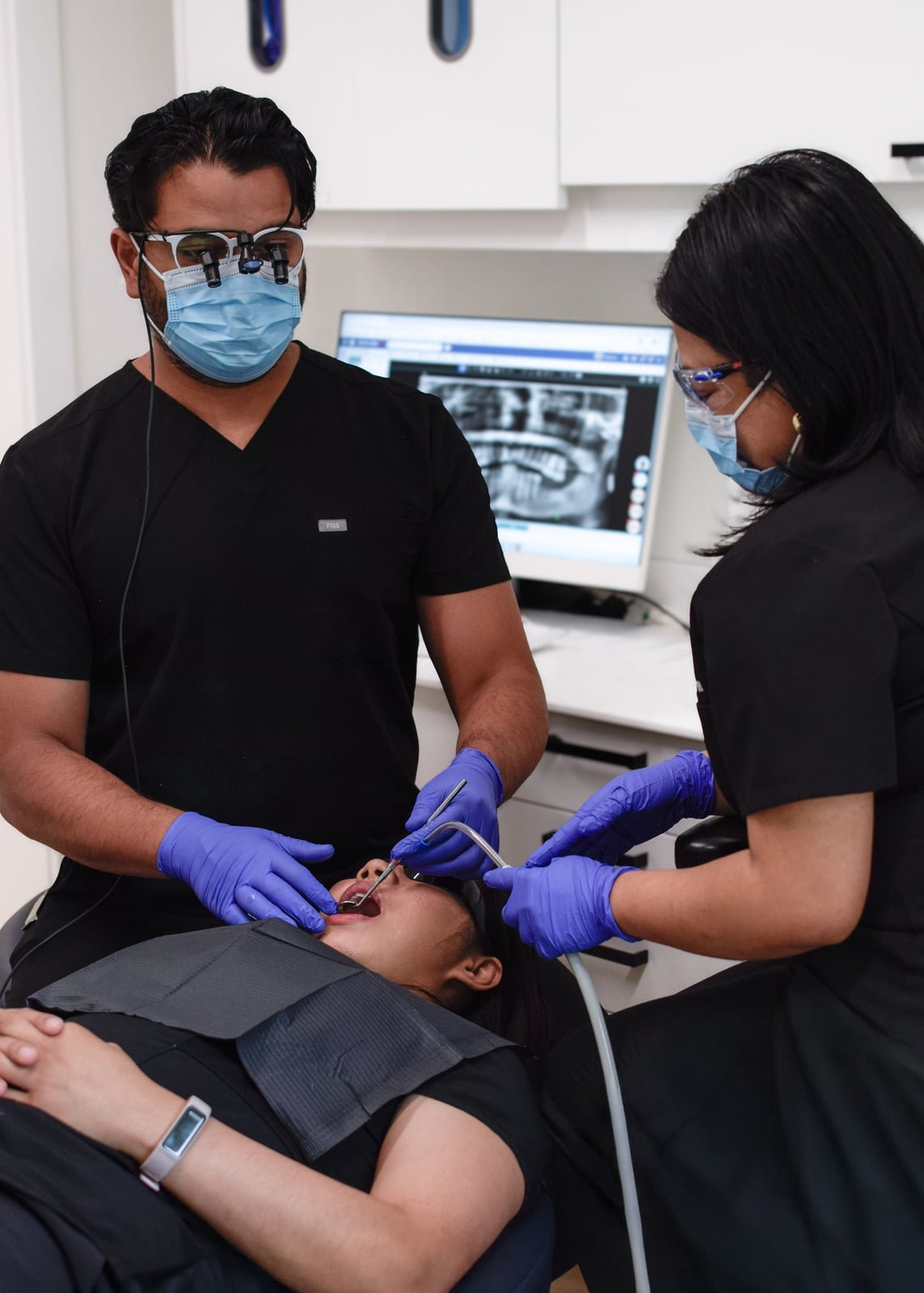 Dr. AJ Jalota chairside with a patient at Redwater Dental Clinic