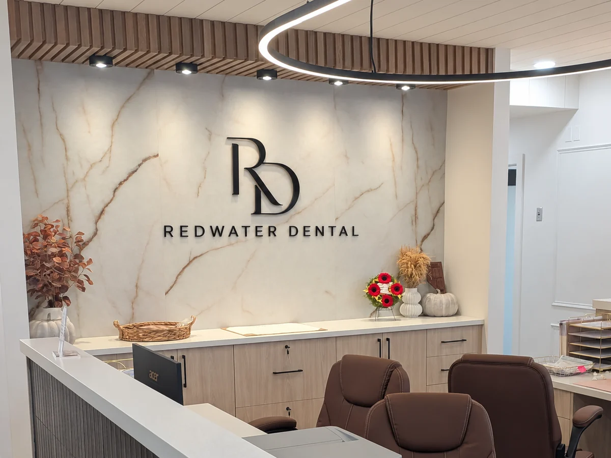 Reception desk with the Redwater Dental logo on the marble feature wall
