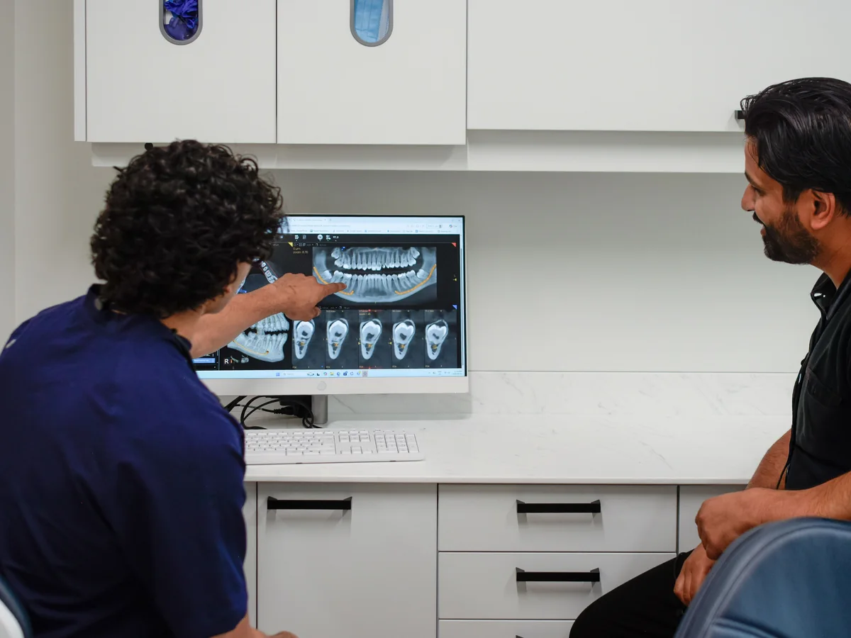 Dentists reviewing dental imaging in a treatment room at Redwater Dental Clinic